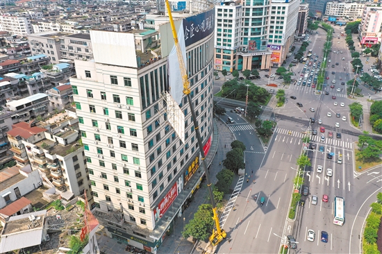 由于要拆除的廣告牌在樓頂，工作人員動(dòng)用75米高的吊機(jī)進(jìn)行作業(yè)。