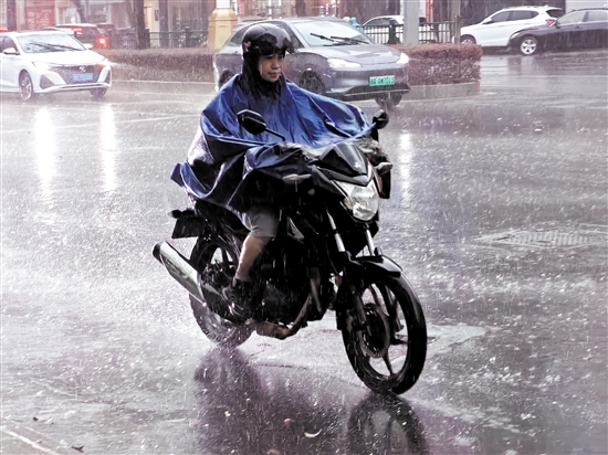 昨天，在市區(qū)東華一路，一位市民騎著摩托車在雨中前行。