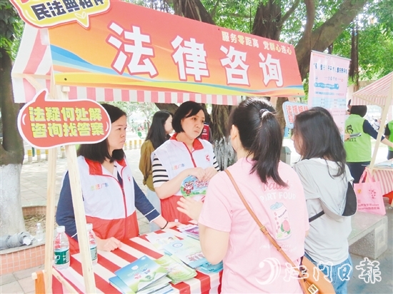 在法律援助攤位，司法系統(tǒng)黨員志愿者耐心解答群眾的法律咨詢。