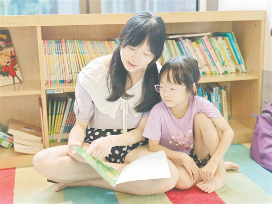 在龍溪湖閱讀中心，一位家長正陪伴孩子讀繪本。