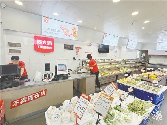 錢大媽生鮮店的工作人員正在線上接單并準(zhǔn)備菜品。