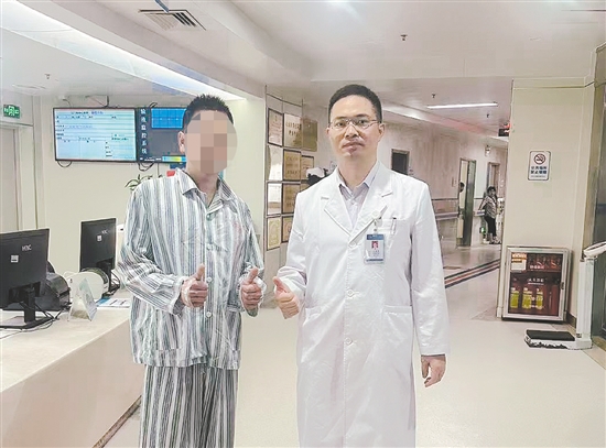 患者和醫(yī)生合影，豎起大拇指表示肯定。