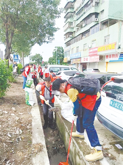 黨員防疫突擊隊(duì)隊(duì)員在開平市長沙街道南島社區(qū)清理垃圾。