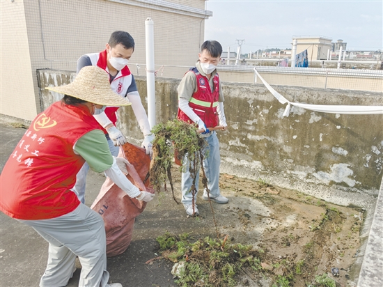 廣大黨員干部當(dāng)先鋒，圖為鶴山市桃源鎮(zhèn)黨員干部正在清理天臺(tái)垃圾。