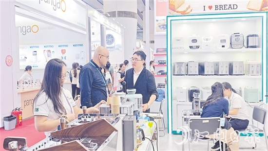 外國(guó)客商在一家蓬江區(qū)家電企業(yè)的展區(qū)前洽談合作。任佳燕