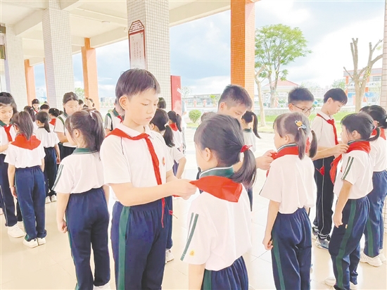 儀式上，老隊(duì)員為新隊(duì)員戴上鮮艷的紅領(lǐng)巾。