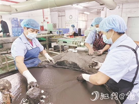 工作人員將裹稻草灰漿的咸蛋放到干稻草灰滾動一下，就完成咸蛋包裹工藝。